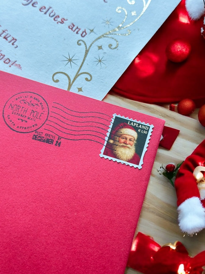 Father Christmas red envelope with Lapland postage stamp and gold foil lettering